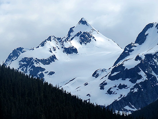 Hohe, mit viel Schnee bedeckte Berge leuchten im Hintergrund.