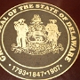 Great Seal of the State of Delaware<br />Mit dem Staatsmotto Liberty and Independence, Freiheit und Unabhängigkeit.<br />1681 vergab König Karl II. die Provinz Pennsylvania an William Penn. Die dort bald darauf eintreffenden Agenten Penns berichteten diesem, dass die Provinz keinen Zugang zur Küste mehr hätte, würde es zu Feindlichkeiten mit den Kolonien kommen, die an beiden Seiten des Delaware River und der Bay lagen. Penn reichte daraufhin beim Königshaus ein Gesuch ein, ihm auch jenes Land auf der Westseite des Delaware River und der Bay zu übereignen, das unterhalb seiner Provinz lag. Dieser Bitte wurde im März 1682 durch James, den Duke of York (und späteren Jakob II.), entsprochen. Penn erhielt das Land der heutigen Countys New Castle, St. Jones und Deale.