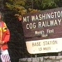 Zur großen Attraktion wird seit 1869 die älteste auf einen Berg führende, mit Dampf angetriebene Zahnradbahn betrieben, die Mount Washington Cog Railway. Von der Marshfield Base Station aus, in der Nähe von Bretton Woods auf 823 m Höhe gelegen, überwindet sie zwischen Mai und Oktober den 5 km langen und ca. 1200 m hohen Aufstieg an der Westflanke des Berges in 90 Minuten. Hierbei werden etwa 1 t Kohle und 3800 l Wasser verbraucht. Jede der sieben alten, nach dem ursprünglichen Arbeitsprinzip aufgebauten kleinen Loks schiebt einen Wagen mit 56 bzw.70 Passagieren den Berg hinauf. Dabei geht es über eine aus Baumstämmen gezimmerte Unterkonstruktion mit einer mittleren Steigung von 25%. Zwei Ausweichstellen werden angefahren, um die talwärts fahrenden Züge auf der eingleisigen Strecke vorbeizulassen. Vor der ersten, auf 1200 m gelegenen, wird nochmals Wasser aufgenommen bevor die Fahrt über die Jakobsleiter geht, die mit über 37% Steigung nur von der Pilatusbahn in der Schweiz an Steilheit übertroffen wird. Bergab - Wagen und Lok sind nicht miteinander verkoppelt - wird der Wagen vom Wagenbremser manövriert. Die Lok bremst sich allein, hauptsächlich über die Dampfkolben.<br /><br />Besucht am 1.10.1997